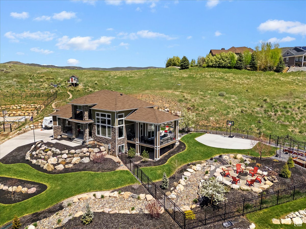 Back of house with stone siding and a patio