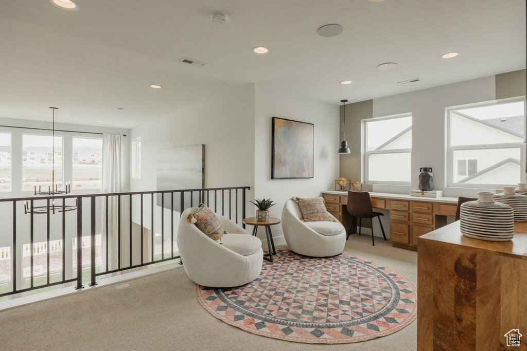 Sitting room featuring light colored carpet, an office area, plenty of natural light, and recessed lighting