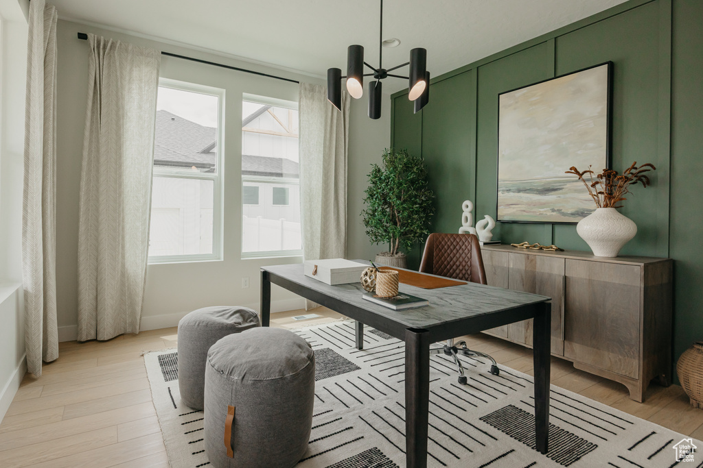 Office space with healthy amount of natural light, light wood finished floors, baseboards, and a chandelier