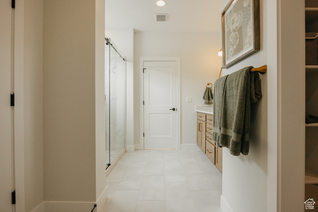 Bathroom with a marble finish shower, vanity, and baseboards