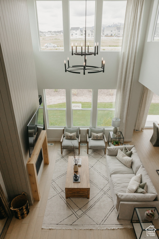 Living room featuring wood finished floors, a chandelier, and a high ceiling