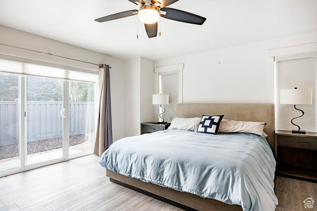 Bedroom with access to outside, wood finished floors, and a ceiling fan