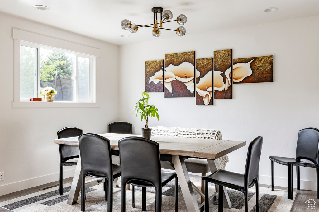 Dining room with baseboards, a chandelier, wood finished floors, and recessed lighting