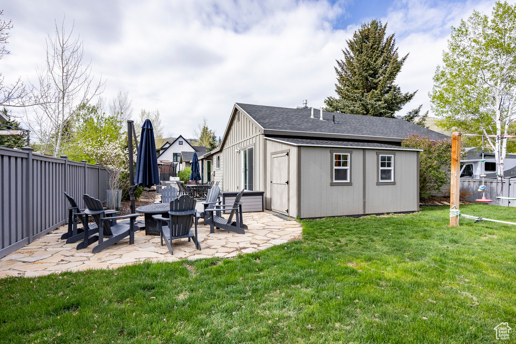 View of yard featuring a patio, a fire pit, and an outbuilding