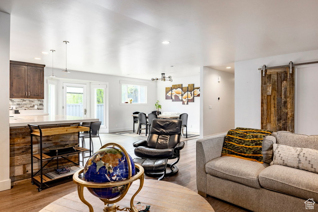 Living area featuring light wood-type flooring, recessed lighting, baseboards, and a barn door
