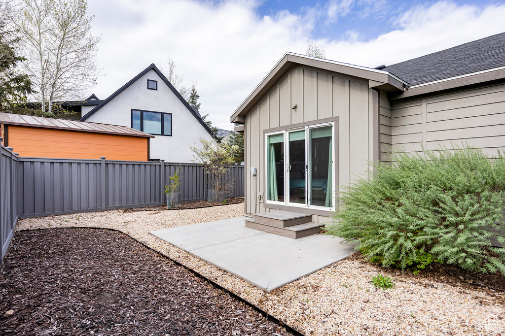 Rear view of property featuring a fenced backyard, a patio, a standing seam roof, metal roof, and board and batten siding