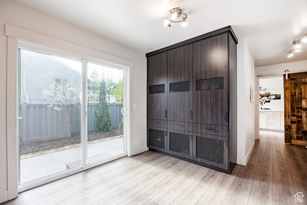 Interior space featuring light wood-style flooring, baseboards, and a barn door