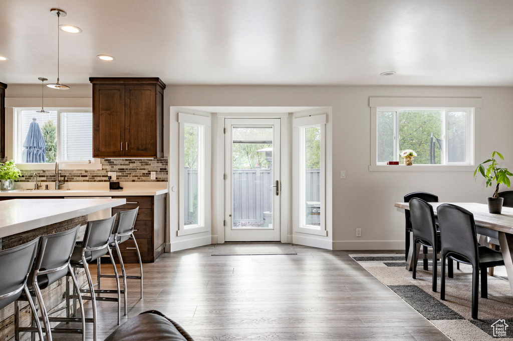 Dining space with plenty of natural light, wood finished floors, baseboards, and recessed lighting