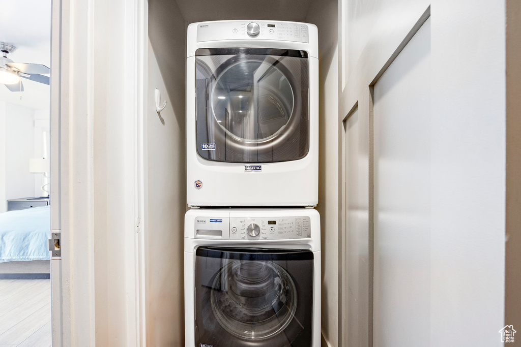 Laundry area featuring stacked washer and clothes dryer and a ceiling fan