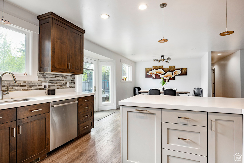 Kitchen featuring dishwasher, a sink, light countertops, and recessed lighting