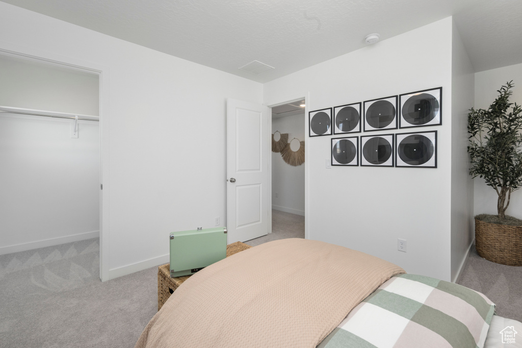 Bedroom with carpet flooring, baseboards, and a closet
