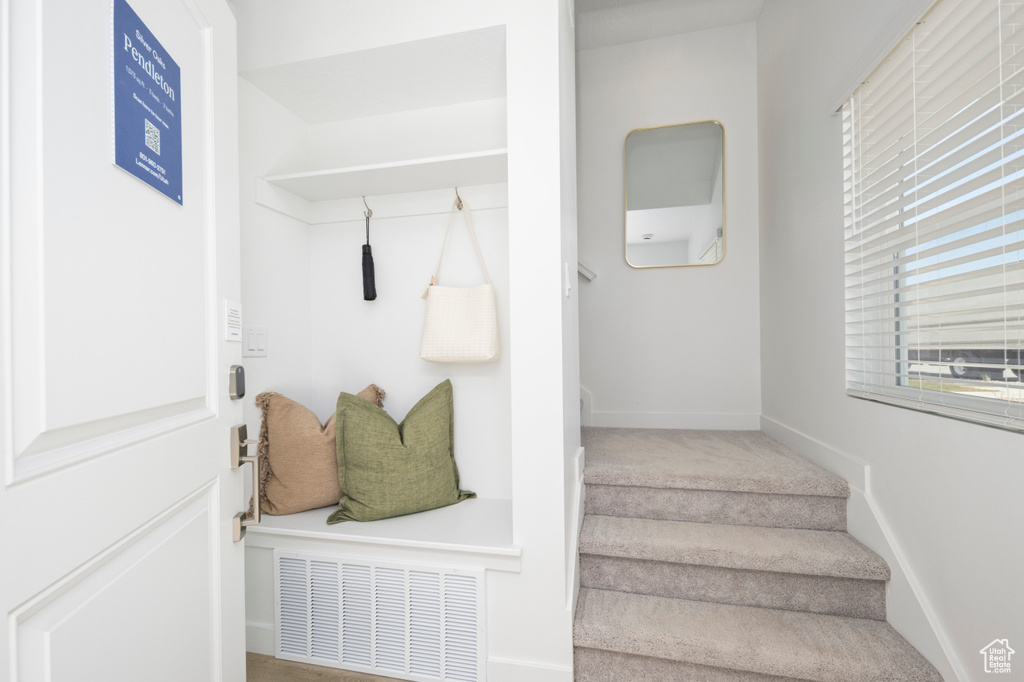Mudroom featuring baseboards and carpet