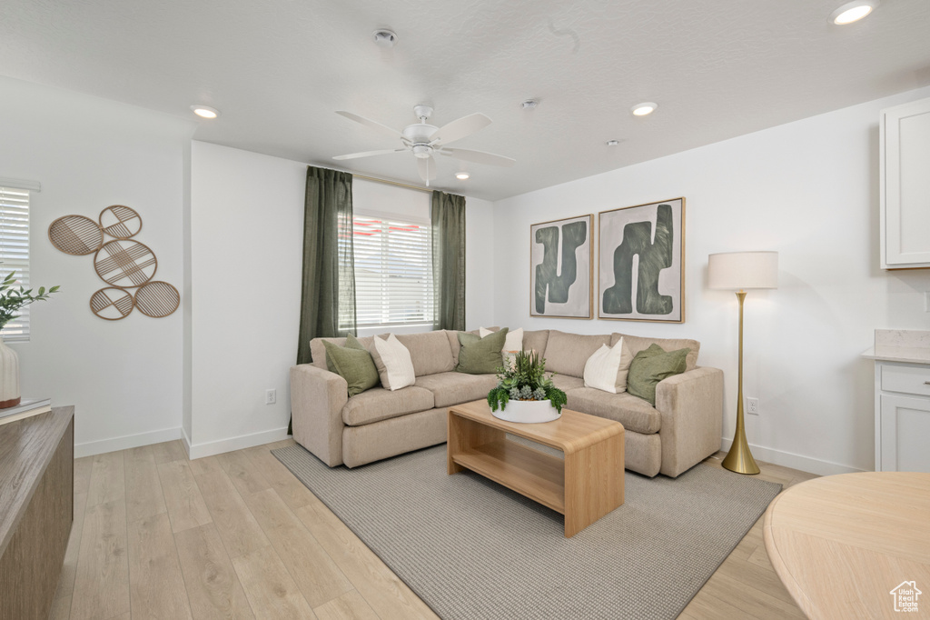 Living area with ceiling fan, recessed lighting, light wood-style flooring, and baseboards