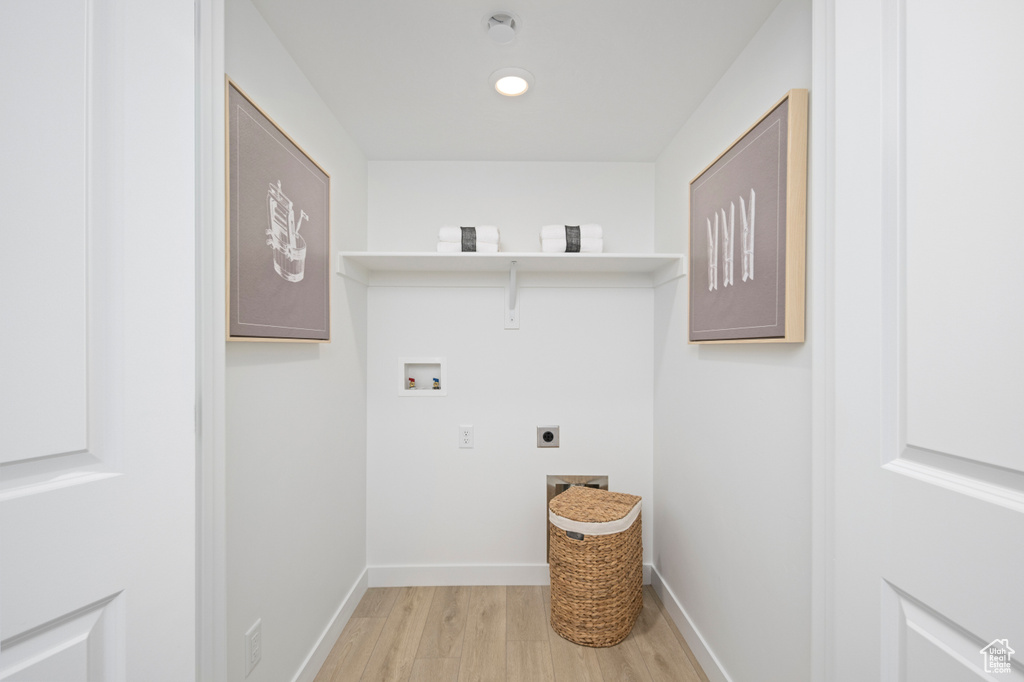 Washroom with washer hookup, light wood finished floors, hookup for an electric dryer, and baseboards