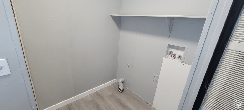 Clothes washing area featuring laundry area, light wood-style flooring, and washer hookup