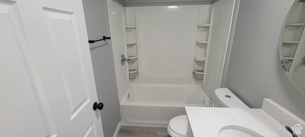 Bathroom with vanity, bathing tub / shower combination, toilet, and wood finished floors