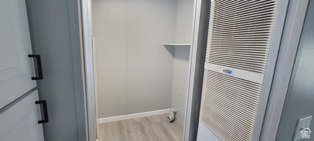 Room details featuring baseboards, a heating unit, and wood finished floors