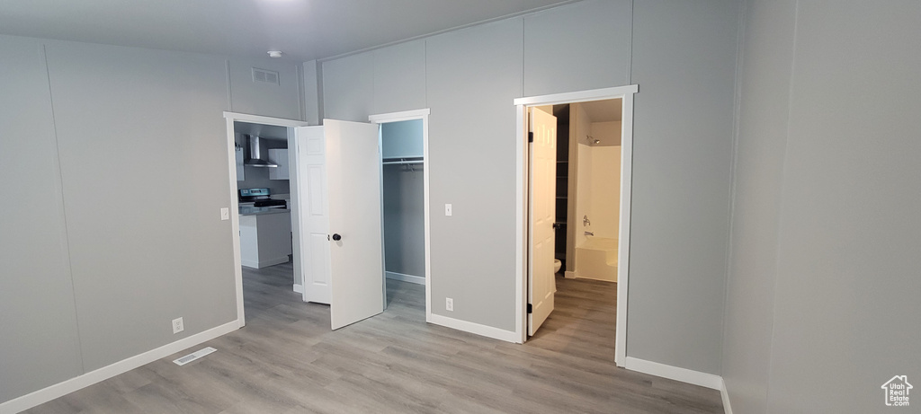 Unfurnished bedroom with baseboards, visible vents, and wood finished floors
