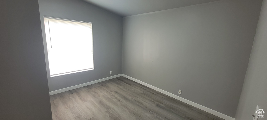 Empty room featuring baseboards, plenty of natural light, and wood finished floors