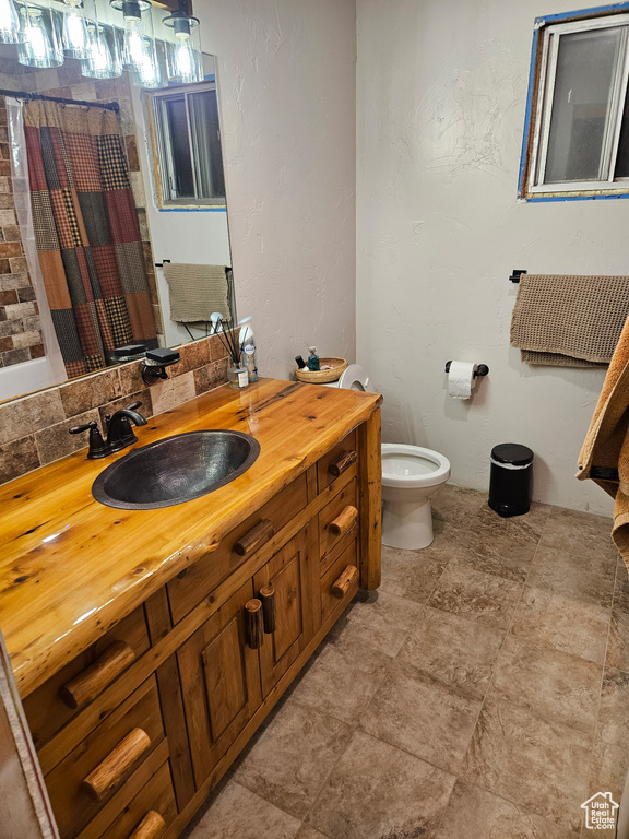 Full bath featuring toilet, a shower with shower curtain, and vanity