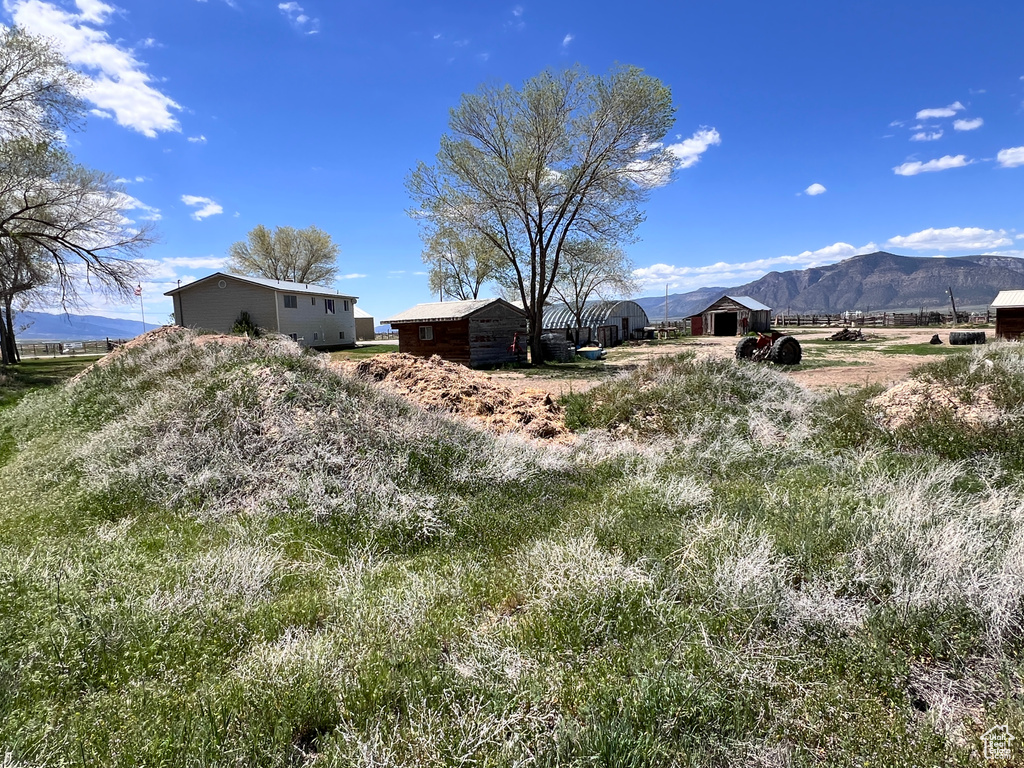 View of yard with a mountain view, a rural view, and an outbuilding