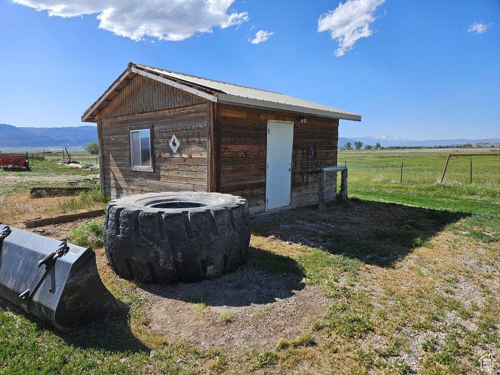 View of outbuilding with a view of countryside, fence, and an outdoor structure