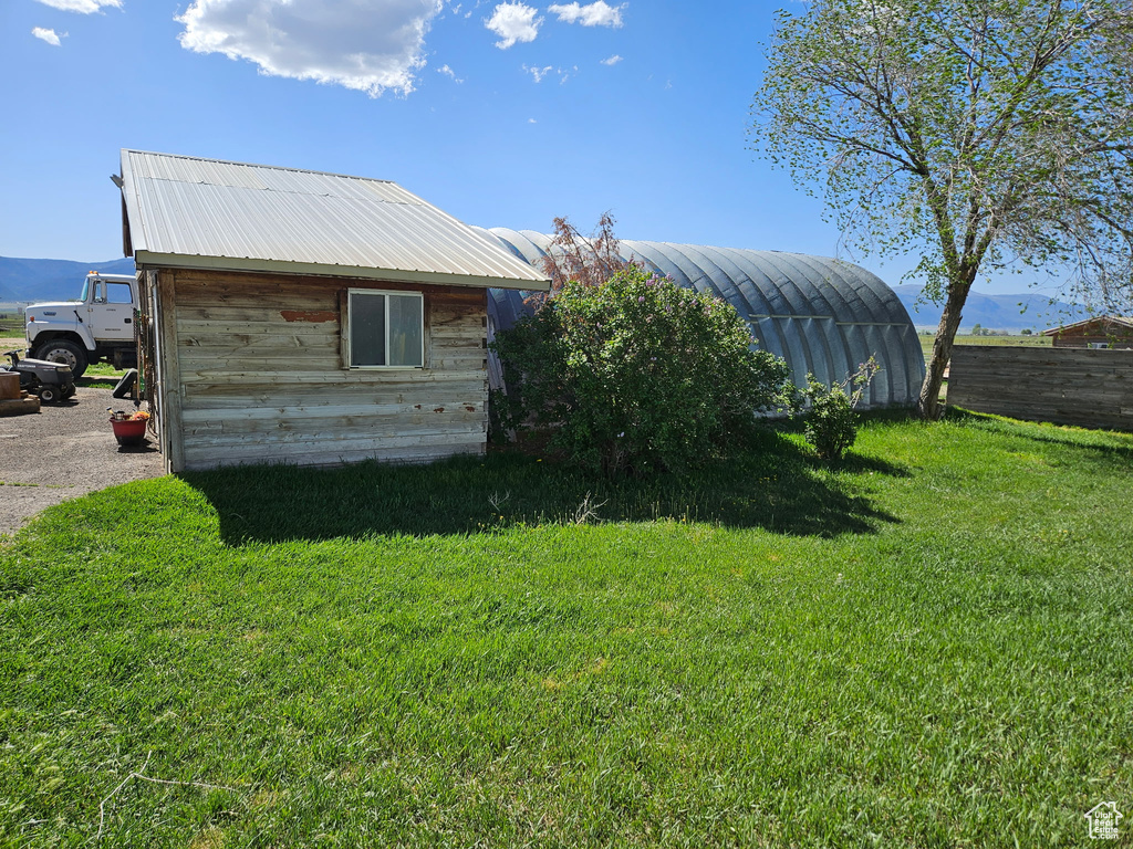 View of property exterior with metal roof, an outbuilding, and a storage shed