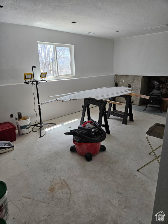 Recreation room with a textured ceiling and concrete floors