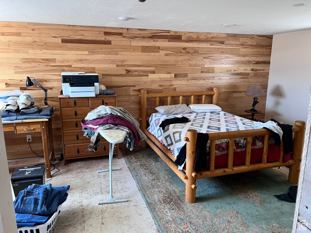 Bedroom featuring wood walls and a textured ceiling