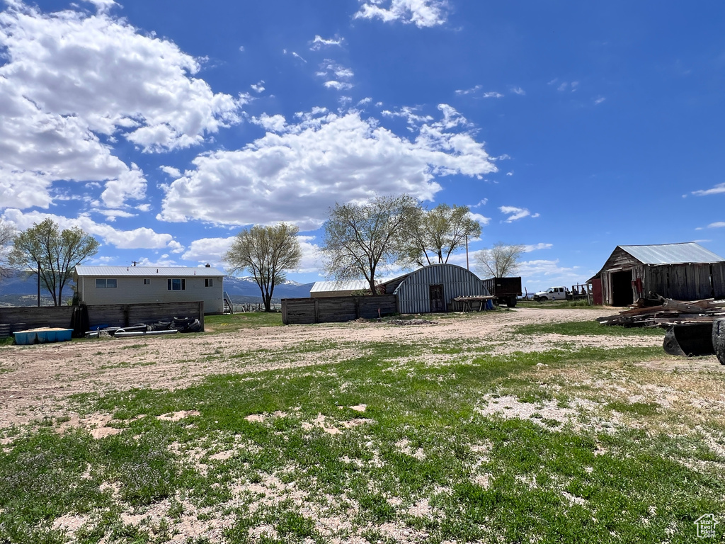 View of yard with a pole building and an outdoor structure