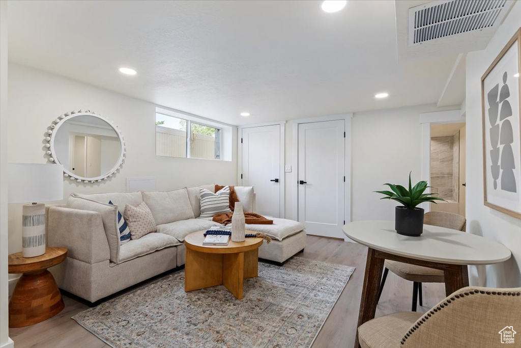 Living area with light wood-style floors and recessed lighting