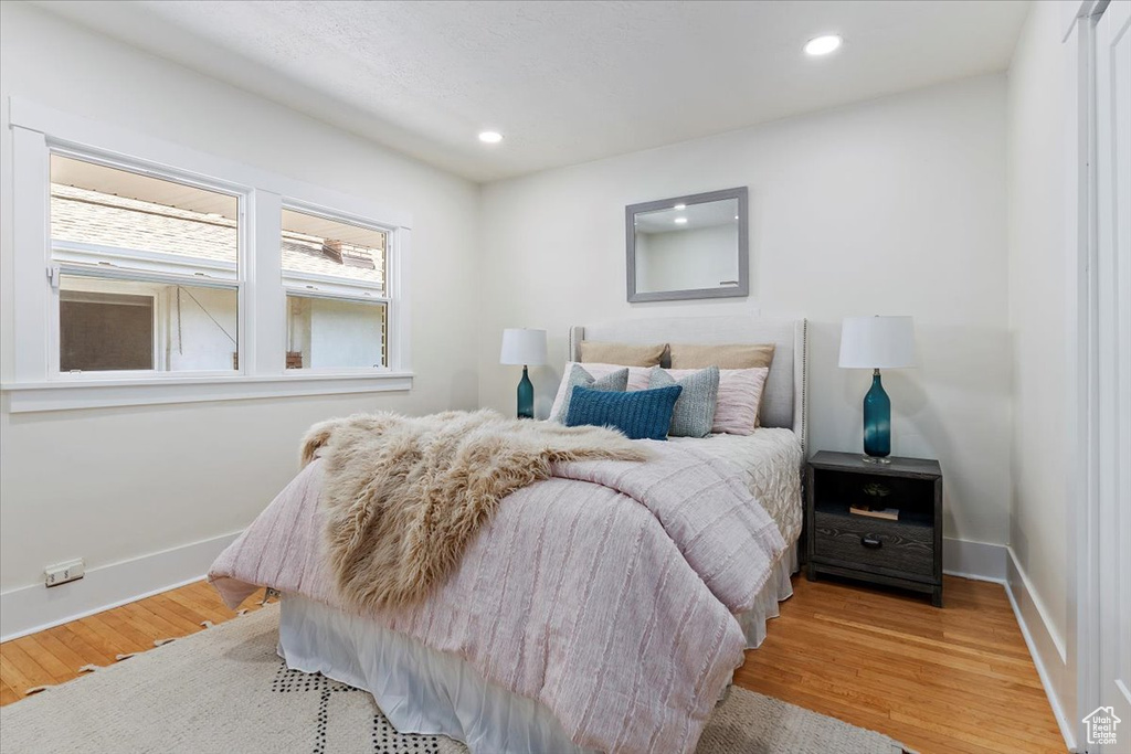 Bedroom with light wood-style floors, recessed lighting, and baseboards