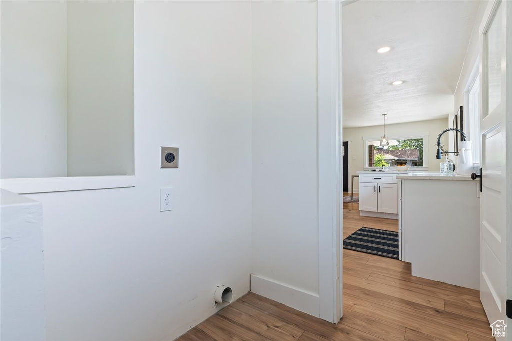 Laundry room with hookup for an electric dryer, light wood-type flooring, and recessed lighting