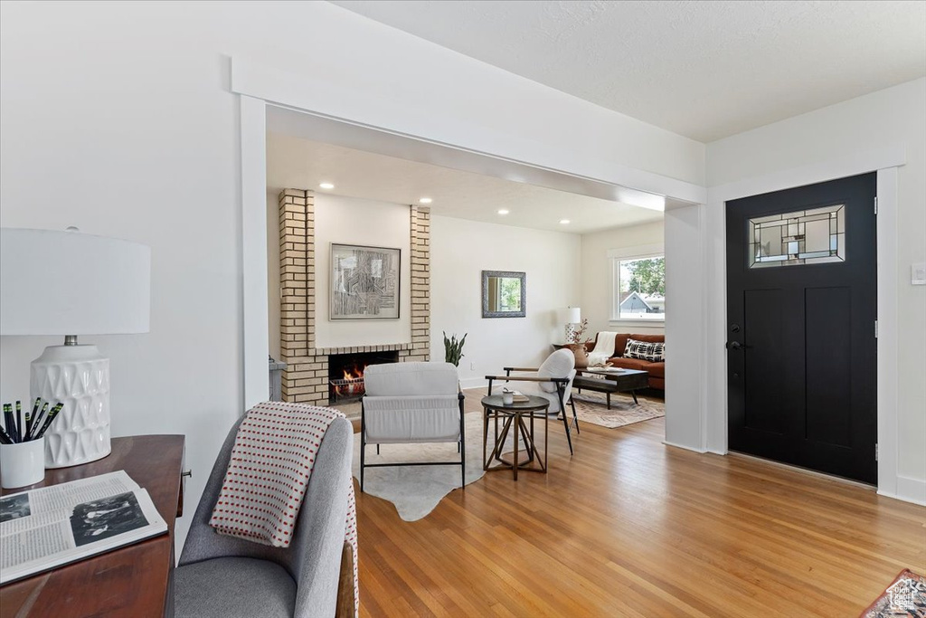 Entryway featuring light wood-type flooring, a fireplace, and recessed lighting