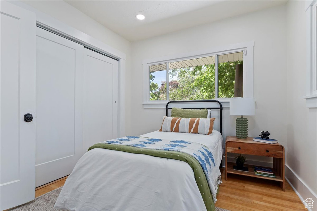 Bedroom with light wood-style floors, a closet, recessed lighting, and baseboards