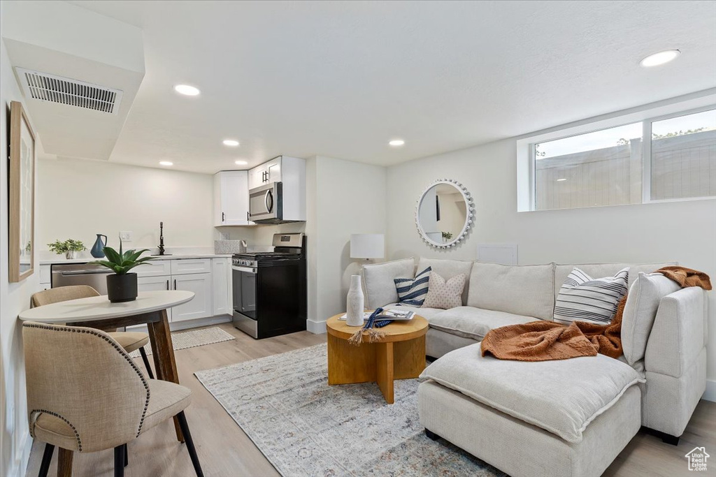Living room featuring light wood finished floors and recessed lighting