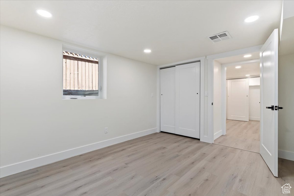 Unfurnished bedroom with light wood-style flooring, baseboards, recessed lighting, and a closet