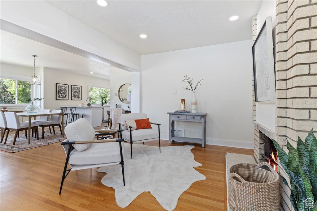 Living area with light wood-style flooring, a fireplace, recessed lighting, and baseboards