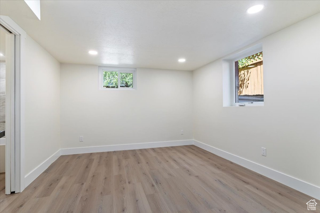 Basement with light wood-type flooring, recessed lighting, and baseboards