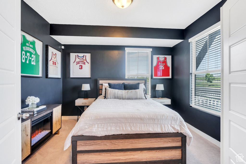 Bedroom with light colored carpet and baseboards