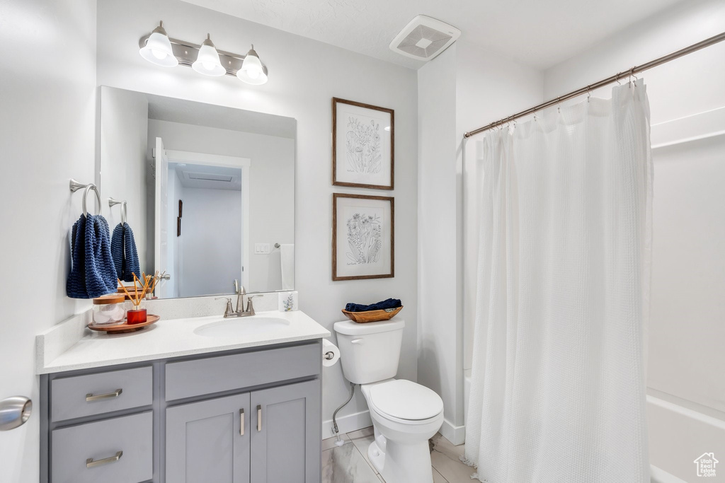 Bathroom featuring toilet, vanity, and baseboards