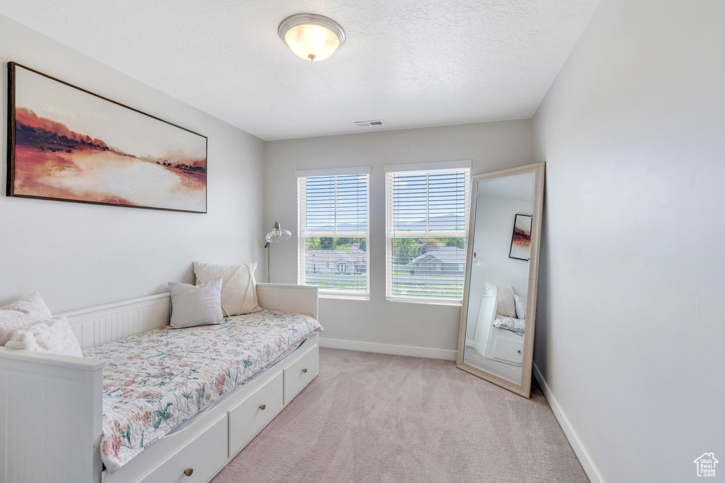 Bedroom featuring light colored carpet and baseboards