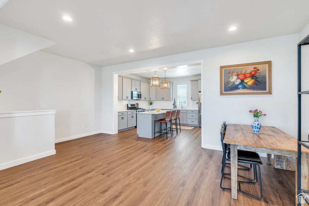 Dining room with light wood-type flooring, baseboards, and recessed lighting