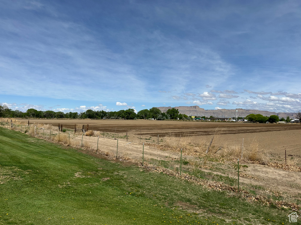 View of yard featuring fence, a rural view, and a mountain view