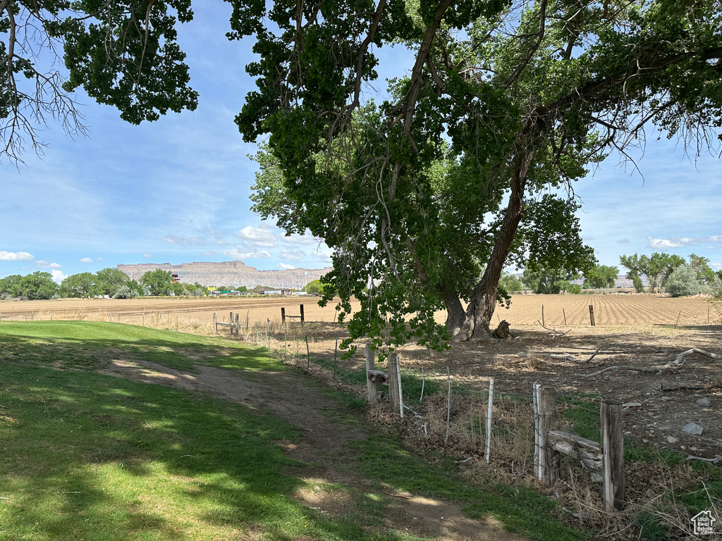View of yard featuring a rural view, fence, and a mountain view