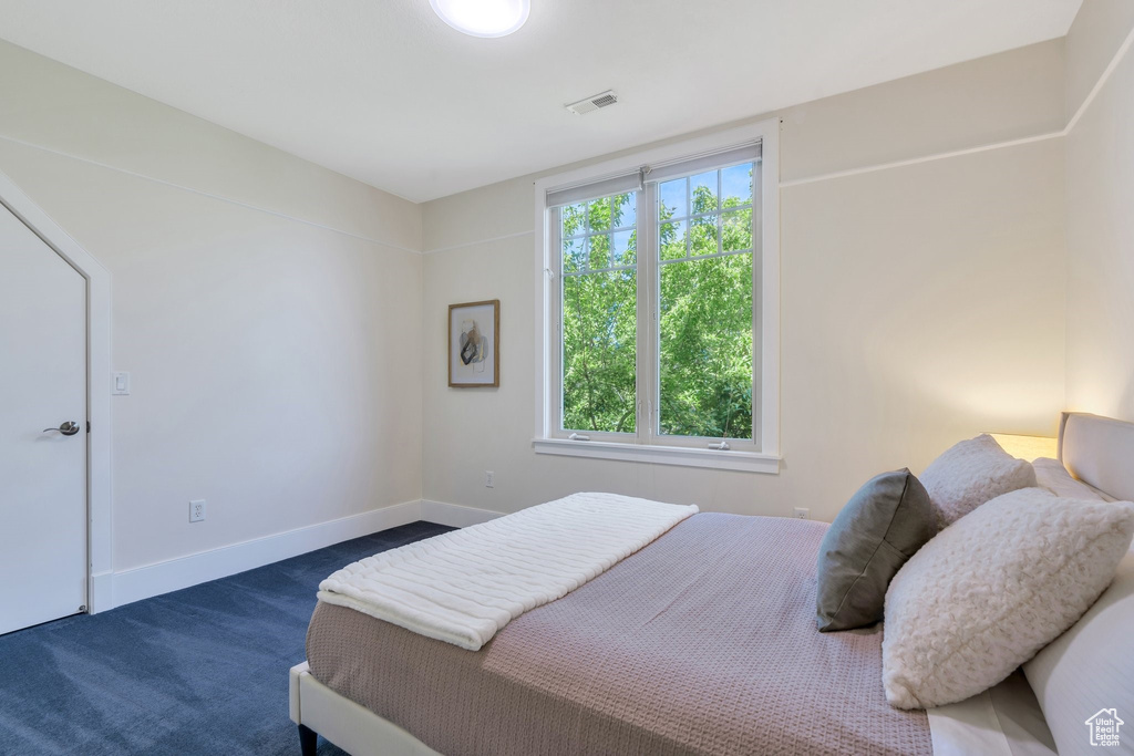 Bedroom with dark carpet and baseboards