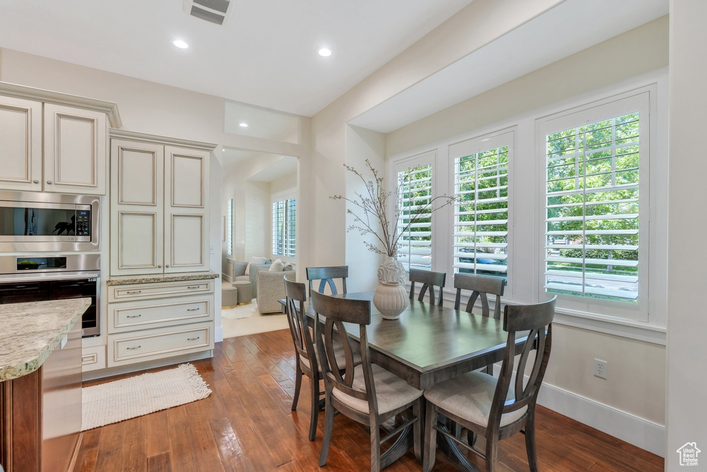 Dining area featuring dark wood-type flooring, recessed lighting, and baseboards