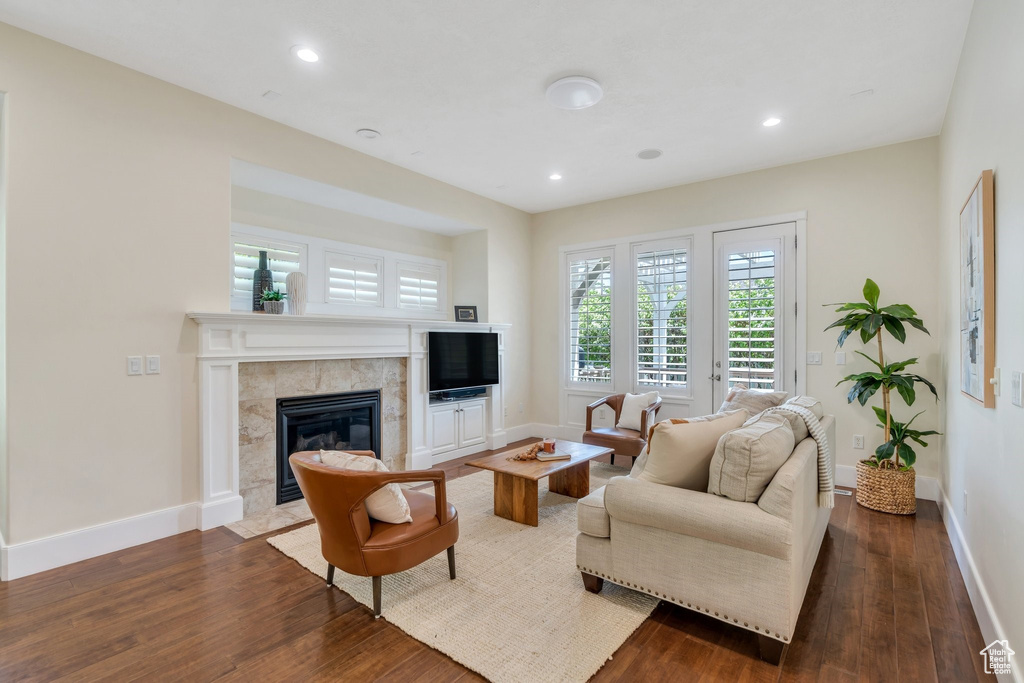 Living area featuring baseboards, dark wood-style flooring, a fireplace, and recessed lighting