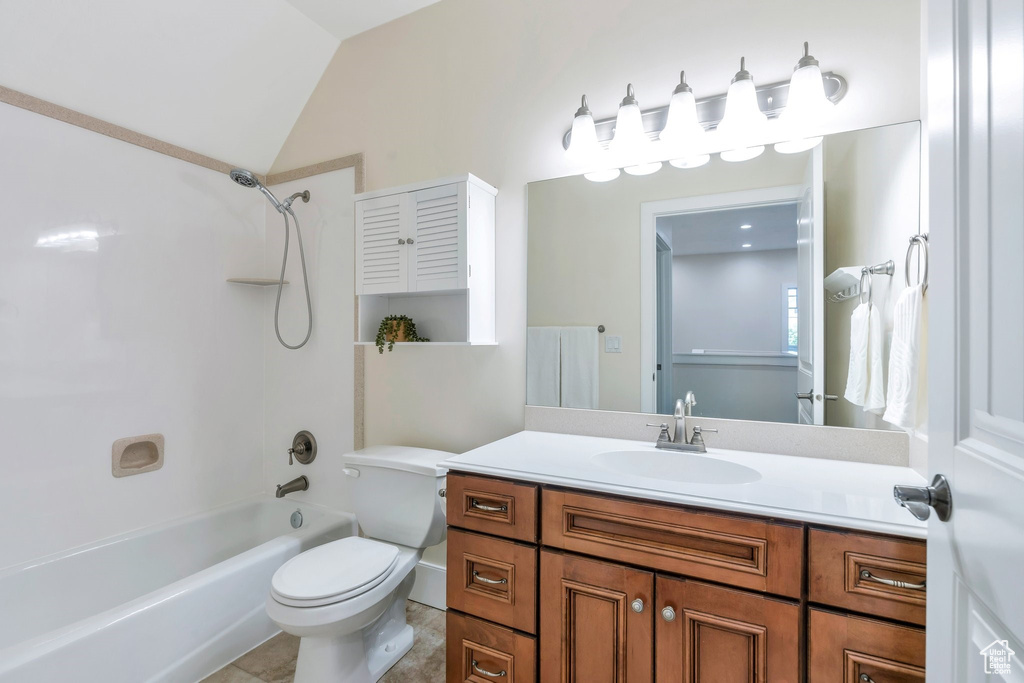 Bathroom with toilet,  shower combination, vanity, and vaulted ceiling