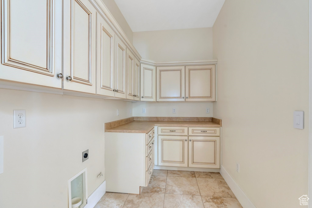 Laundry room with cabinet space, electric dryer hookup, and baseboards